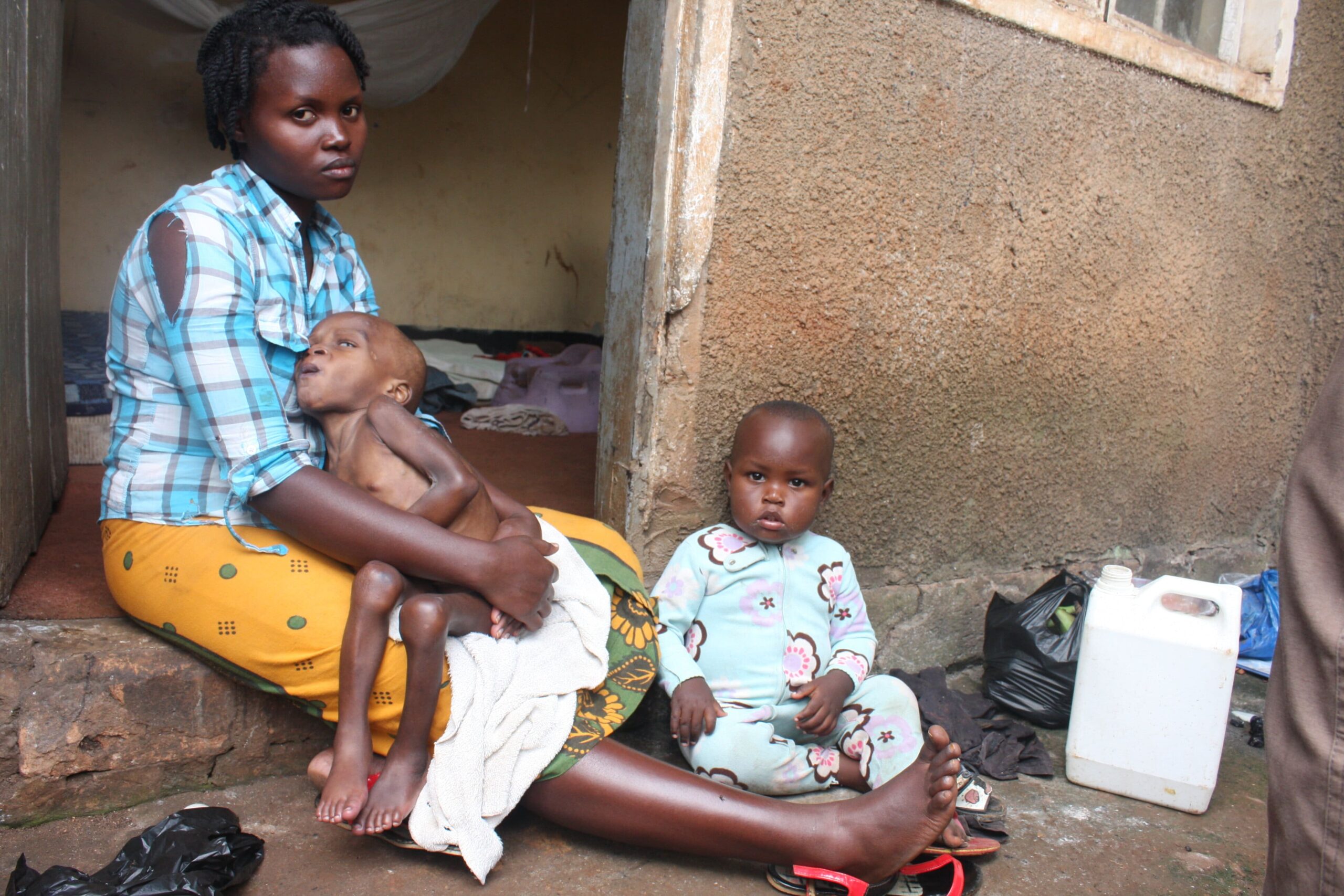 Annet Alinda who is stuck with her two children after the landlord throw her away. (1)