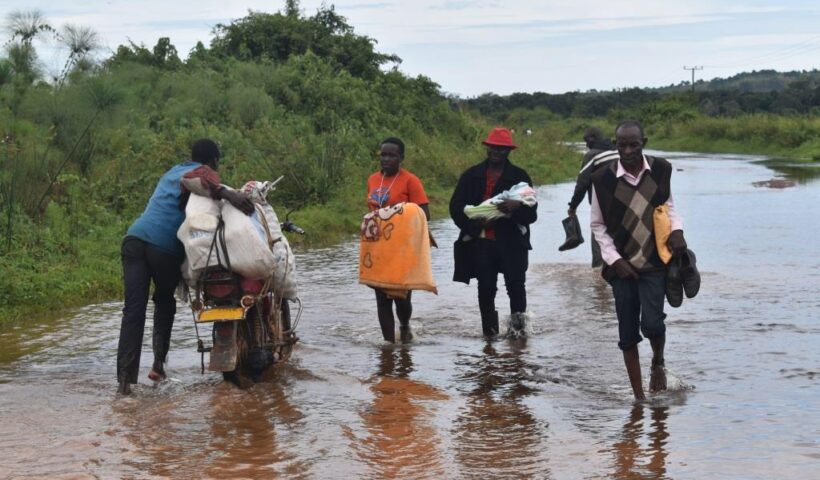 Ugandan local residents walking through flooded zones