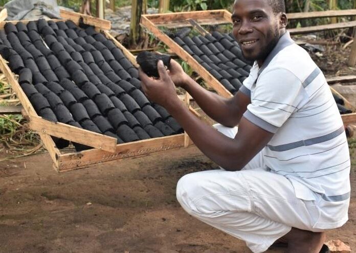 Sadick Katende displays some of the briquettes they produce at Mpawu Briquettes Ltd