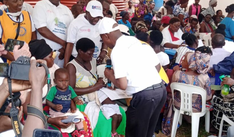 Governor for District 9213, Mike Ssebalu immunizing a child at Ngogwe camp.