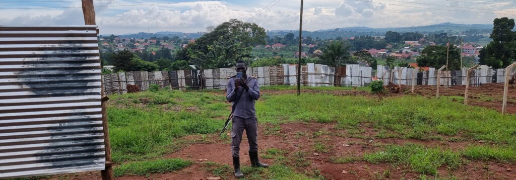 One of the hired private security guards taking pictures of whoever passes near the contested fenced land. 
