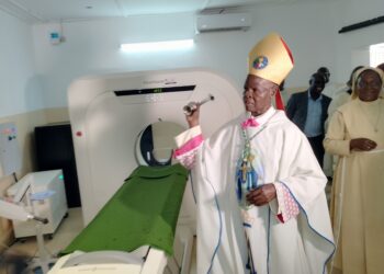 Bishop blessing the CT-Scan with Holy water