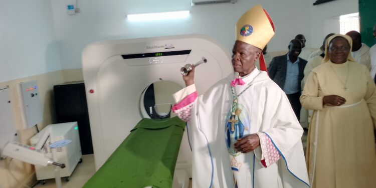 Bishop blessing the CT-Scan with Holy water