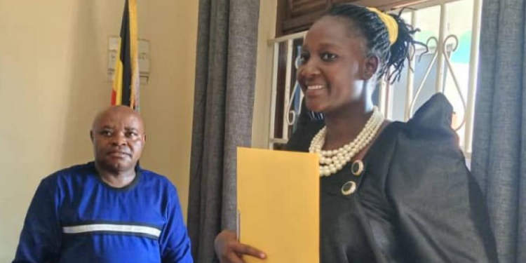 Hanna Grace Lalam shows her nomination file besides the Dokolo Returning Officer.