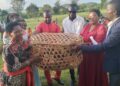 Hon. Stephen Sserubula giving out kroliler chicken to one of the village groups in Lugazi municipality