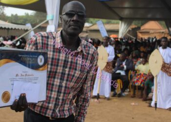 CBS retired reporter Issa Muwembe displays off a certificate of appreciation from the Kamuswaga of Kooki.