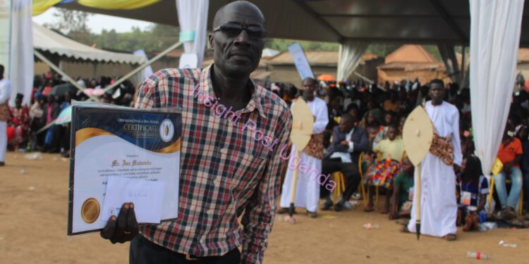 CBS retired reporter Issa Muwembe displays off a certificate of appreciation from the Kamuswaga of Kooki.