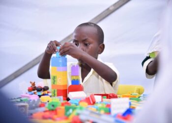 Building the Future: A young boy engages in hands-on learning through pay with blocks.