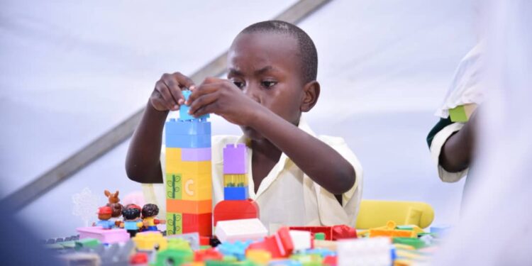 Building the Future: A young boy engages in hands-on learning through pay with blocks.