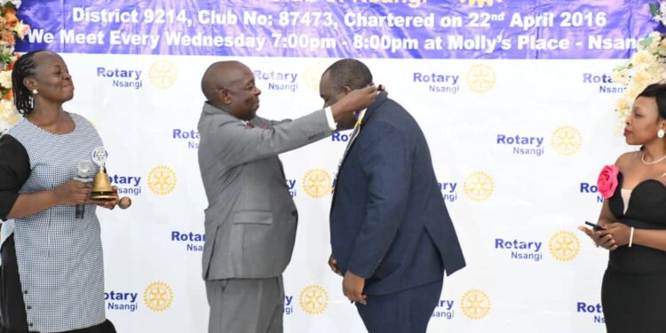 Past District Governor 9214 Mr Peace Taremwa(2rd left) installing Dr Steven Sseruyange as new President Rotary Club of Nsangi in Maya Wakiso District on Sunday .Looking on( right )Mrs Sseruyanga and Ms Enid Tusi