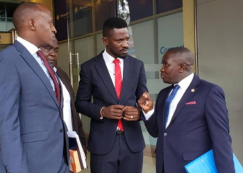NUP President Robert Kyagulanyi speaking with his lawyers Benjamin Katana and George Musisi at the UHRC Offices on Monday