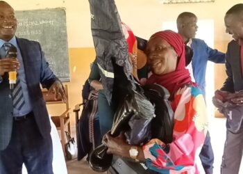 Former Minister Ronald Kibuule handing over kits to para social workers.