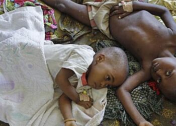 Two children with malaria rest at the local hospital in the small village of Walikale