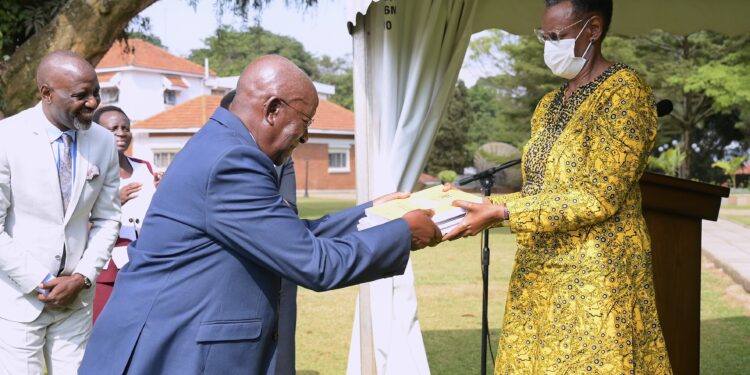 Mushega handing over the report to the minister for Education, Janet Museveni.