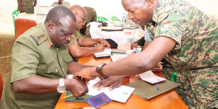 Gen. Peter Elweru signing his retirement form.