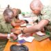 Gen. Peter Elweru signing his retirement form.