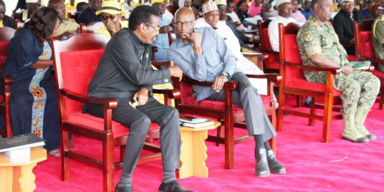 Minister for Security, Maj. Gen. Jim Muhwezi having a light moment with former Inspector General of Police, Gen. Kale Kayihura.