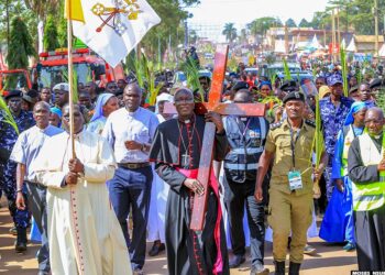 Bishop Christopher Kakooza holds the cross as he leads pilgrims from Lugazi Diocese in a grand entry to the Namugongo Shrine, where they are presiding over this year’s Martyrs Day pilgrimage events.