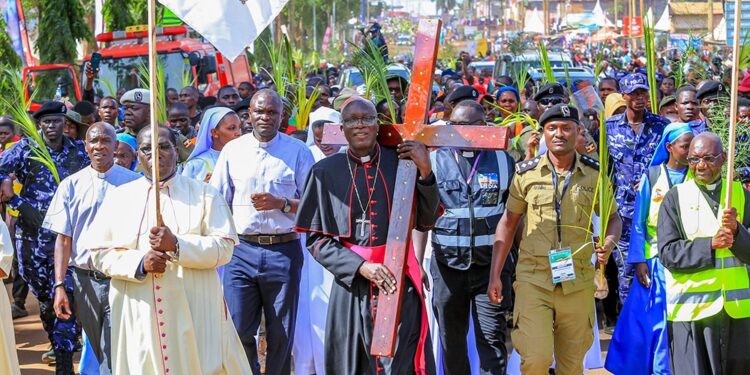 Bishop Christopher Kakooza holds the cross as he leads pilgrims from Lugazi Diocese in a grand entry to the Namugongo Shrine, where they are presiding over this year’s Martyrs Day pilgrimage events.