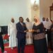 Allan Mawanda hands over UGX 5 million to the Chairperson of the Mukono Muslim Women Savings and Cooperative SACCO.