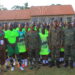 Wazalendo SACCO officials, UPDF participants, organisers, and hosts pose for a group photo after the handover of sports kits in Masaka.