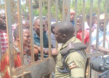 Nambooze and other NUP supporters locked outside the gate.