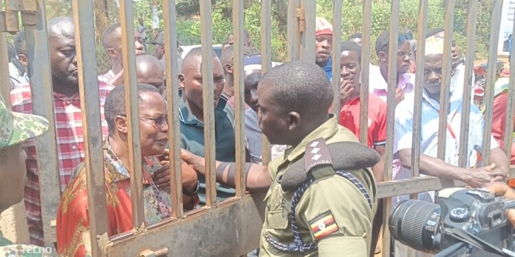 Nambooze and other NUP supporters locked outside the gate.
