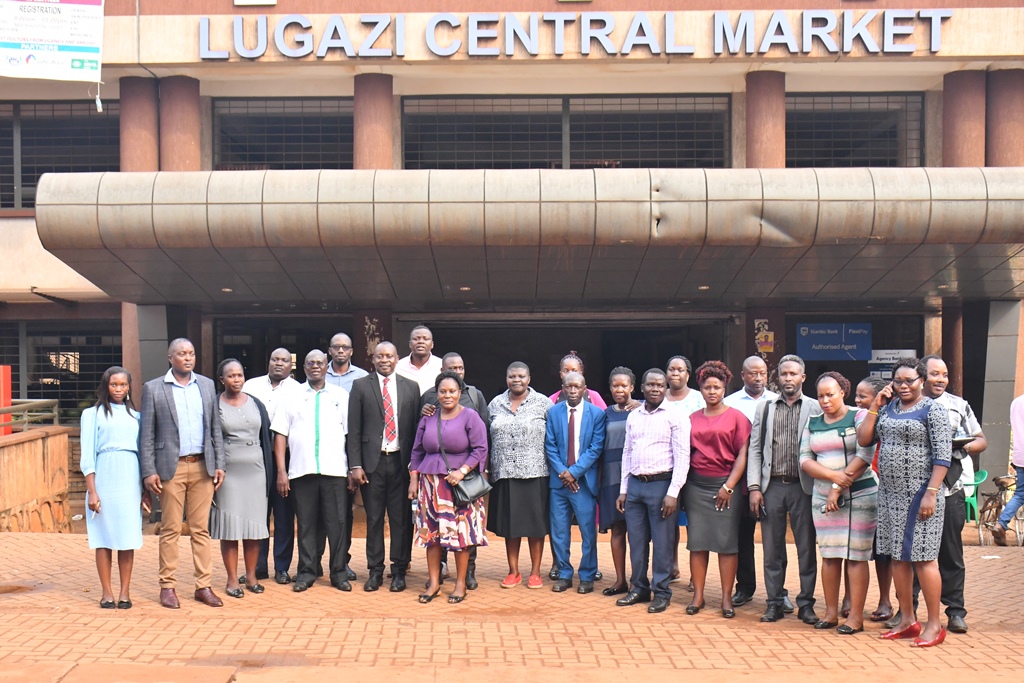Officials from MoLG and MoGLSD and others from Jinja, Lugazi, Kamuli, Iganga, Mayuge and Mbale pose for a photo after visiting a childcare facilities in Luganzi MATIP market.