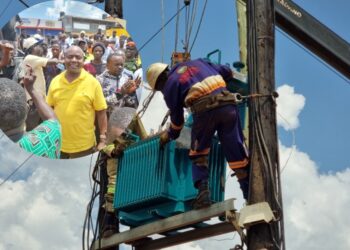 UEDCL technicians install a new transformer in Kalagi as former minister Ronald Kibuule looks on.