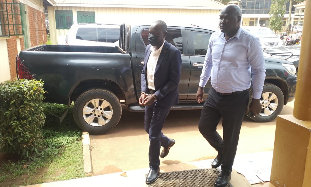 Ssekikubo escorted by detectives to court.