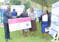 UCU Deputy Vice Chancellor in charge of Finance and Administration hands over a dummy cheque to one of the outstanding researchers.