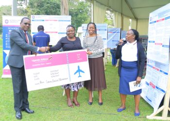 UCU Deputy Vice Chancellor in charge of Finance and Administration hands over a dummy cheque to one of the outstanding researchers.