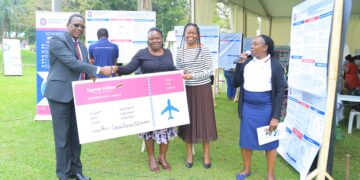 UCU Deputy Vice Chancellor in charge of Finance and Administration hands over a dummy cheque to one of the outstanding researchers.