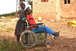 Joseph Sentamu being assited by his daughter. Photo by Davis Buyondo