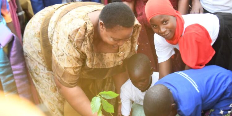 Hon. Babirye Milly Babalanda plants a tree during the International Women’s Day celebrations in Buyende District.