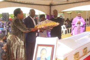 State Minister of Trade Industry and Cooparatives Fredrick Gume Ngobi laying a wreath on the casket during burial. 