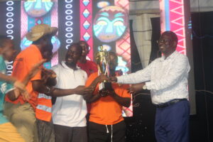 Mr Constatine Mpuuga, R, hands over the trophy to the Mckee House members who won the competition