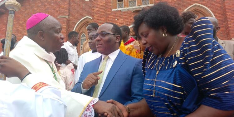 Bishop Jjumba greeting Mpuuga and Juliet Kakande after the Easter Mass