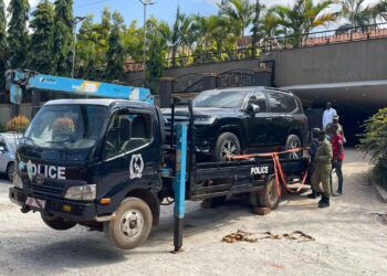 Security teams tow away impounded vehicles for forensic examination during an ongoing investigation.