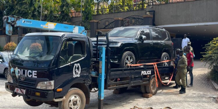 Security teams tow away impounded vehicles for forensic examination during an ongoing investigation.