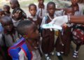 Health workers screen pupils at a school entrance as part of strengthened Ebola prevention measures