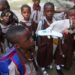 Health workers screen pupils at a school entrance as part of strengthened Ebola prevention measures