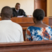 Graphic illustration of a couple appearing before court during a criminal trial.