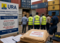URA officials and customs officers inspecting containers at a busy port as importers’ documents lie ready for clearance, highlighting the official cargo verification process amid growing concerns over illegal charges in the logistics chain.