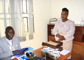 Kaliisizo Town Council Chairperson (Mayor) Richard Sande Ntambaazi handing over the official handover report to the Town Clerk, Resty Nabatanzi, marking the end of his 20-year tenure.