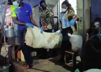 Police officers from Mukono District carry the body of Tikeni Sepela from a restaurant in Wantoni following his sudden deat