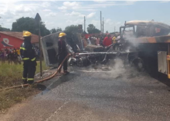 Firefighters work to extinguish flames after two cargo trucks burst into fire following a head-on collision.