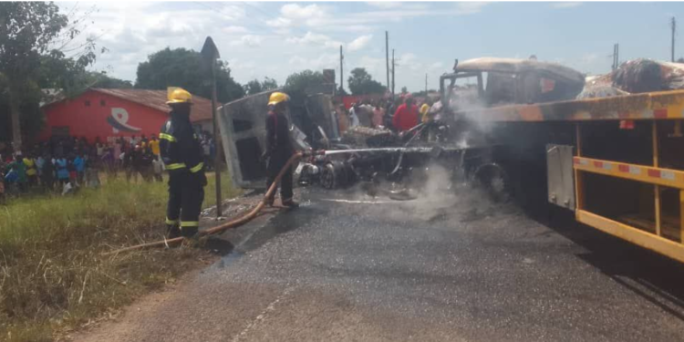 Firefighters work to extinguish flames after two cargo trucks burst into fire following a head-on collision.