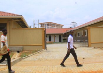 Students of St Kizito Technical Institute Kitovu walking past the new workshop built by government