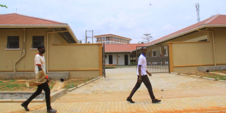 Students of St Kizito Technical Institute Kitovu walking past the new workshop built by government